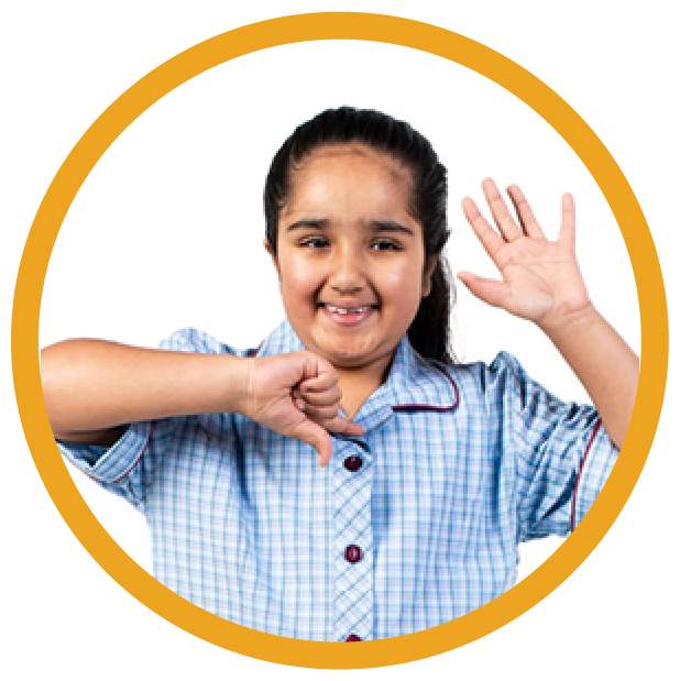 A young person with their hand up smiling.
